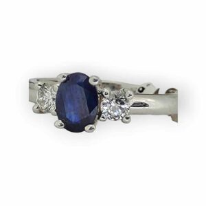 a ring with a blue stone and three diamonds