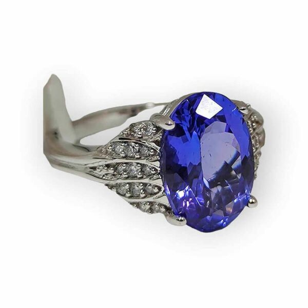 a tan gold ring with a blue stone surrounded by diamonds